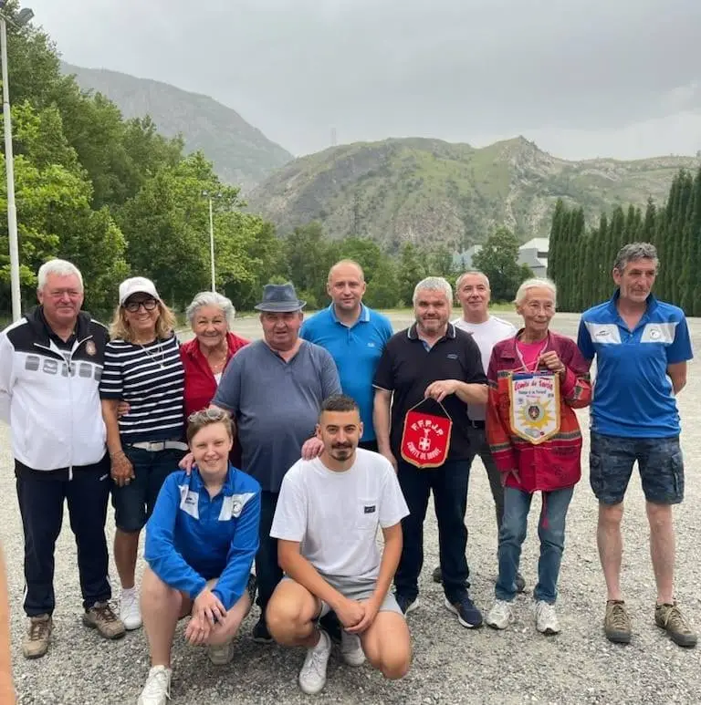 Des membres du club réunis sur le terrain d’été avec le fanion du comité de Savoie